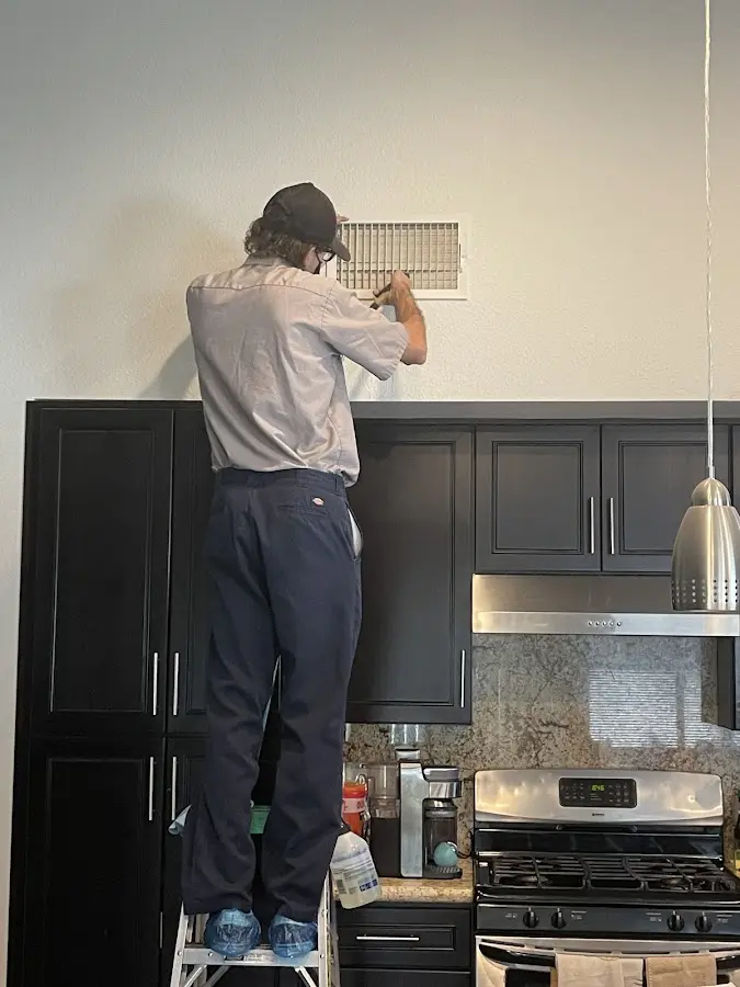 Technician inspecting an air vent during HVAC service in Marshall